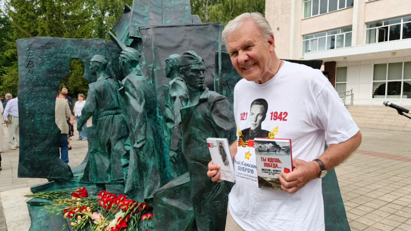 У памятника «Писательская рота» в Козельске в августе 2025 года. Александр Бобров в футболке с портретом своего младшего брата Николая Александровича Боброва (1921—1942), участника Великой Отечественной войны, Героя Советского Союза (1942, посмертно). Фотография Андрея Объедкова («Вечерняя Москва»)